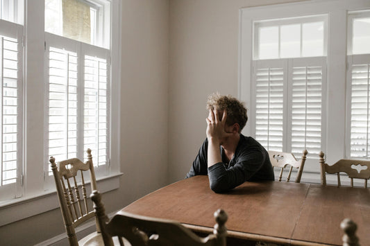 Person sitting at a table with his palm in his face