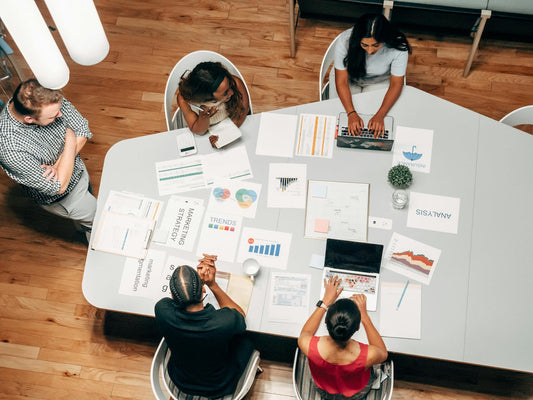 People working around table with papers scattered across the table