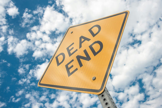 Yellow Dead End sign with clouds in the background