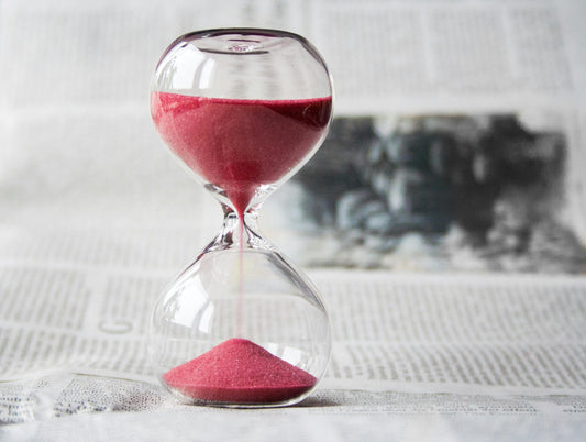 Hour glass with red sand.