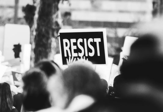 Protest with a sign, "Resist" sticking out. 