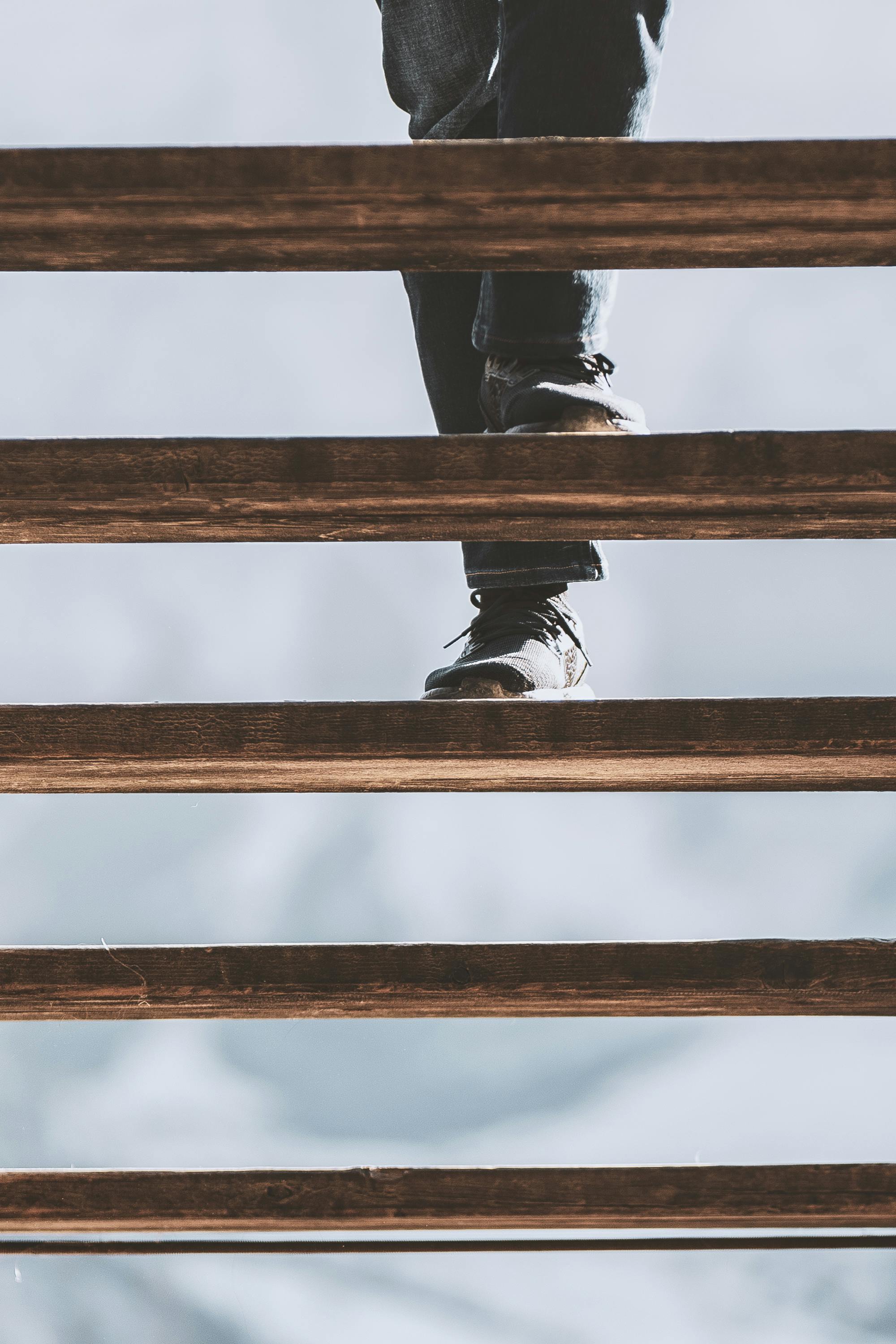 Person walking up wooden stairs with a blurred background