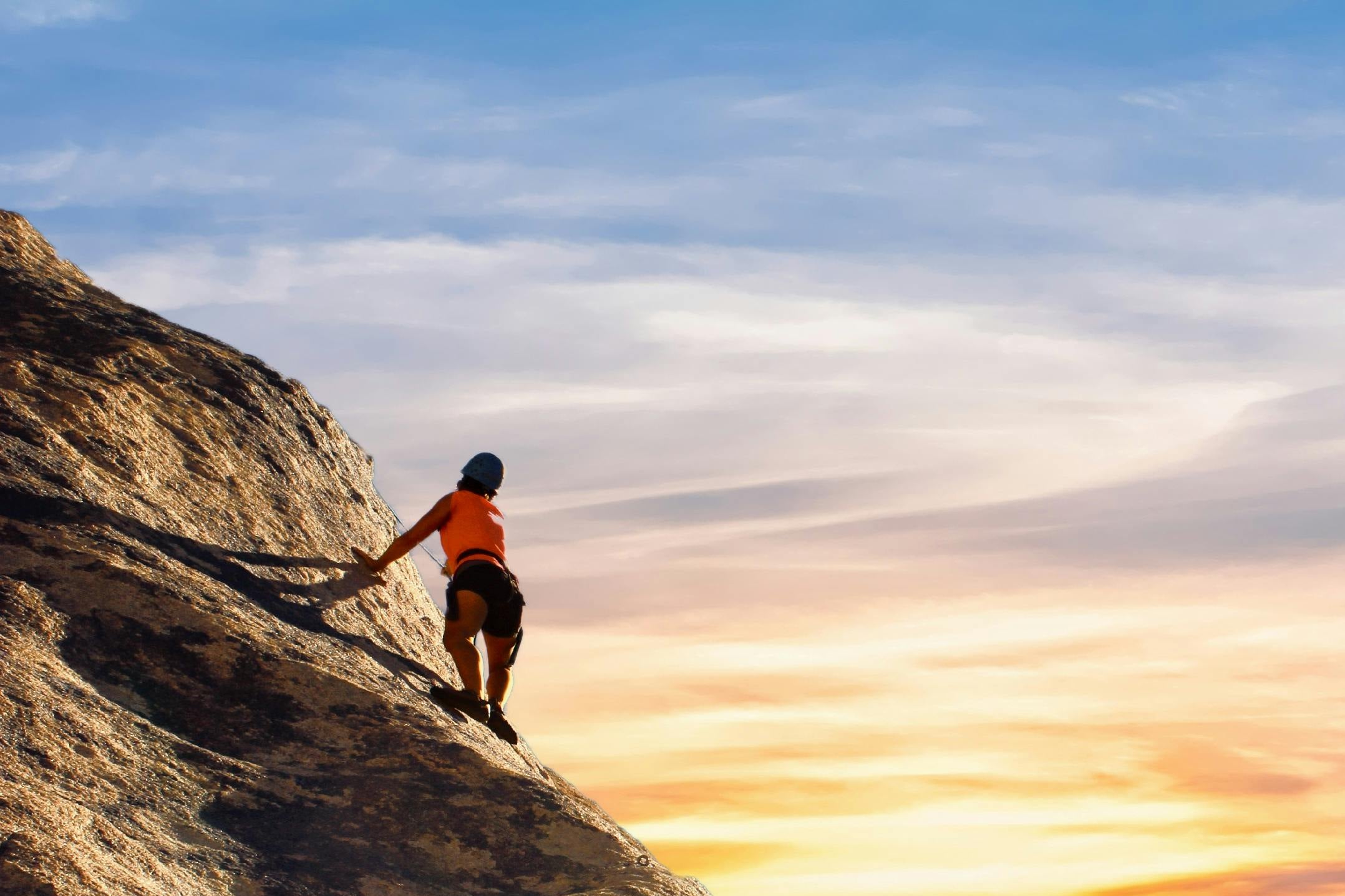 Person climbing  rock cliff
