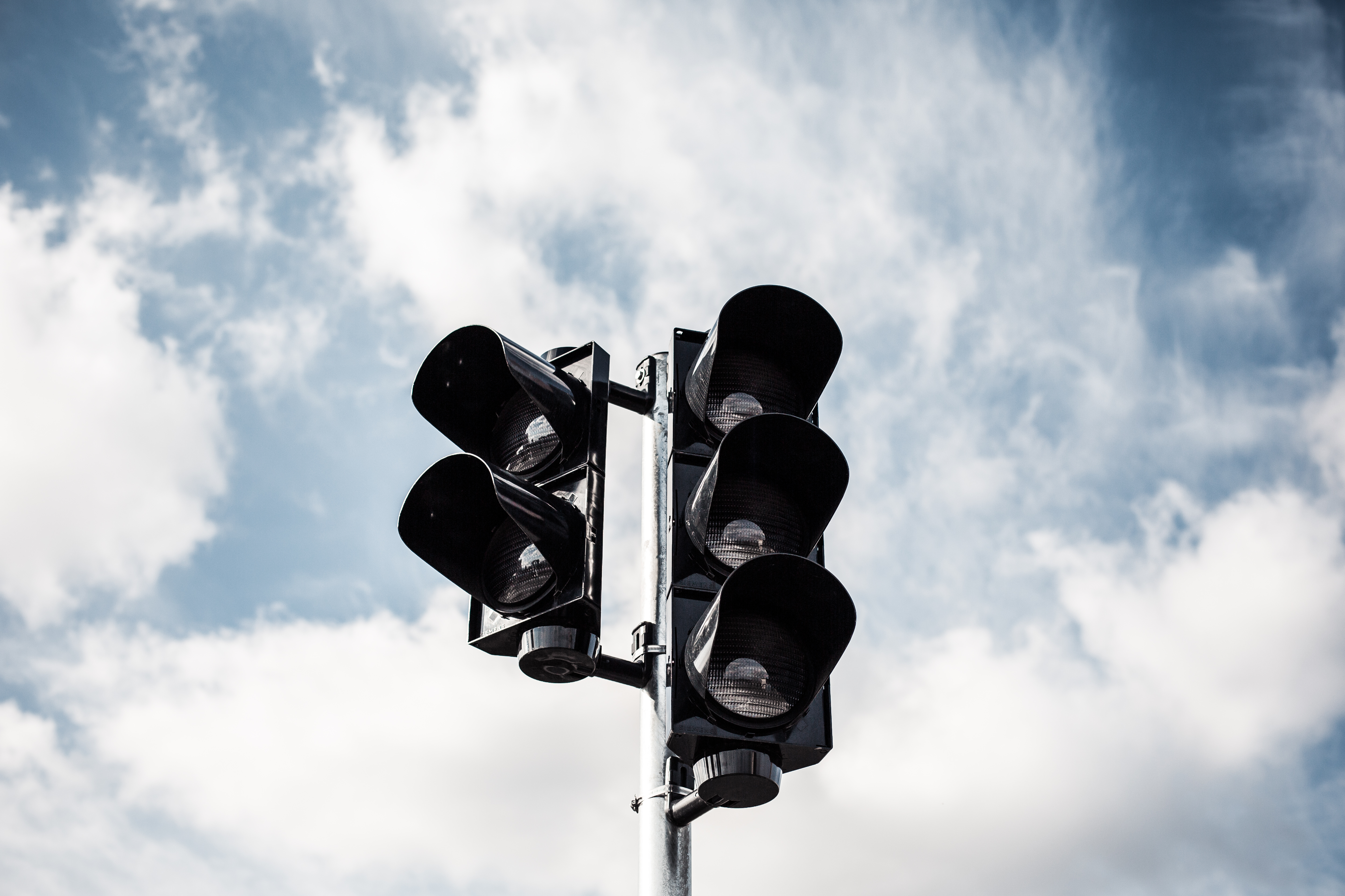 Street light with clouds and blue sky in the background.