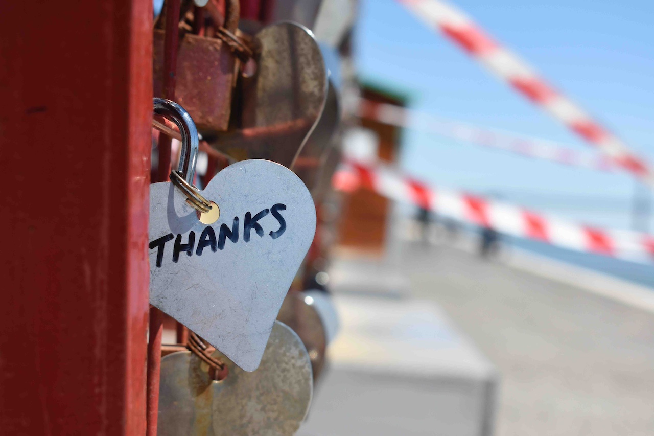 Locks on a fence with one in focus written thanks in a heart shape keychain.