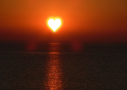 Sunset on the ocean with heart shaped sun representing work that lights you up.