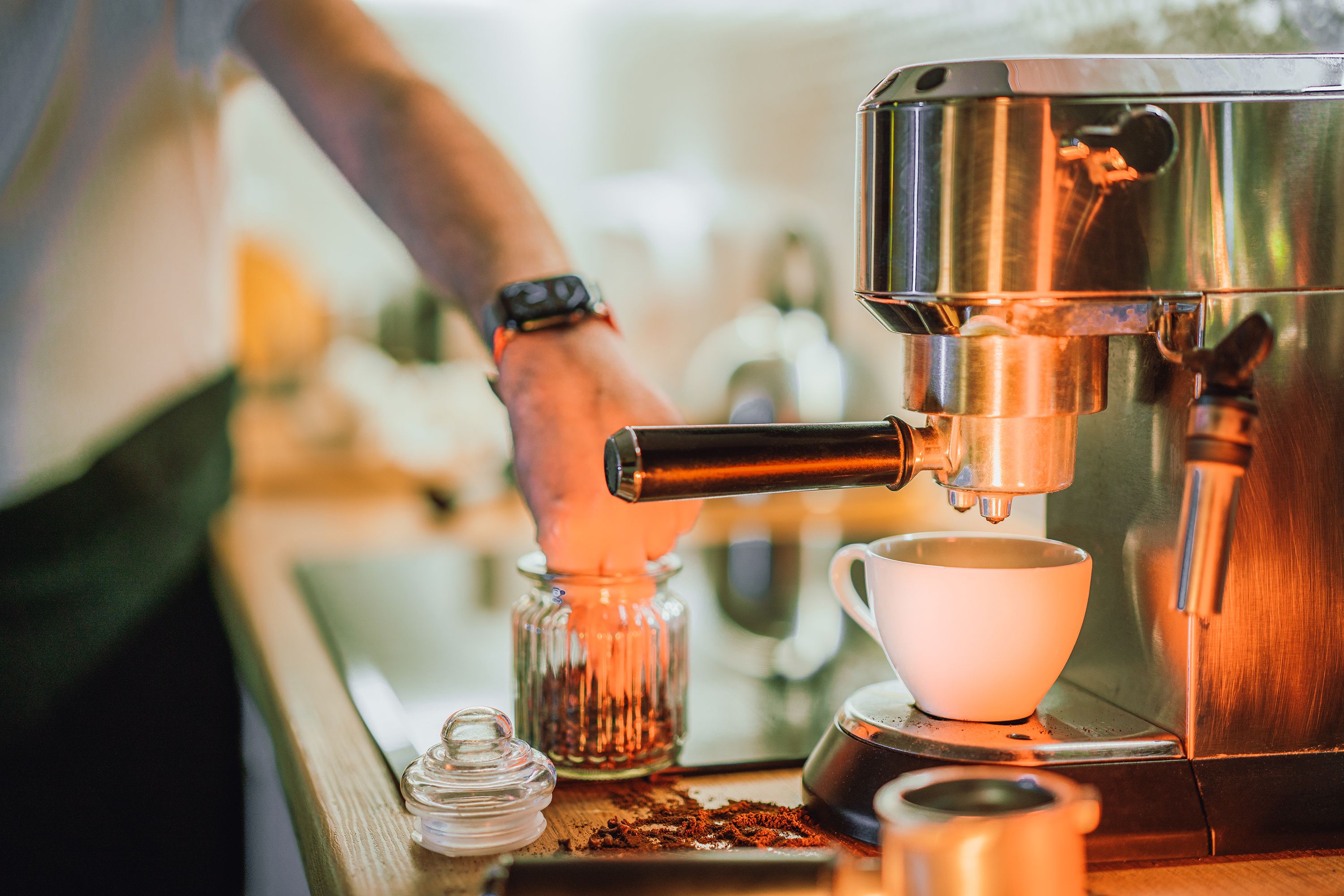 A person paying attention to the craft of making a coffee.